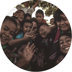 A large group of school children waving