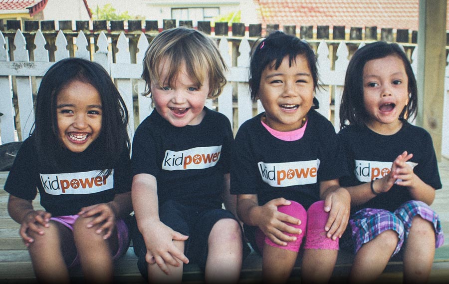 Four preschoolers wearing Kidpower shirts and laughing