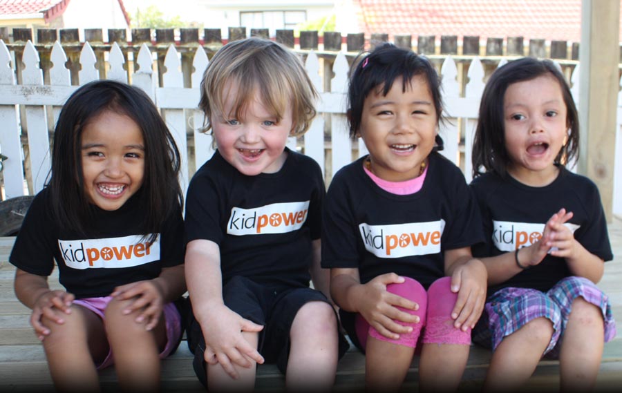 Four preschoolers wearing Kidpower shirts and laughing